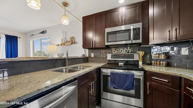 kitchen with sink, hanging light fixtures, light stone countertops, tasteful backsplash, and stainless steel appliances