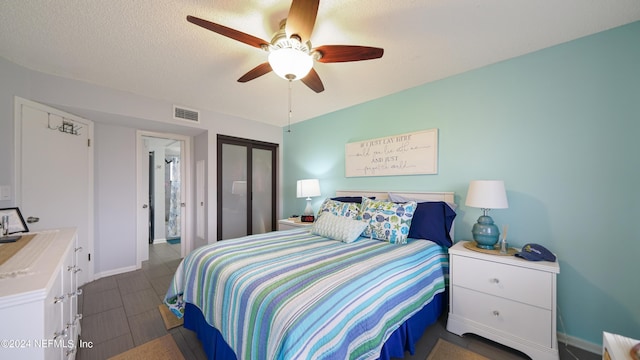 bedroom with ceiling fan and a textured ceiling