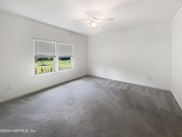 carpeted spare room featuring ceiling fan