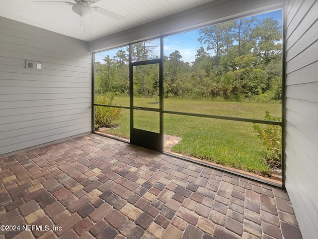 unfurnished sunroom with ceiling fan