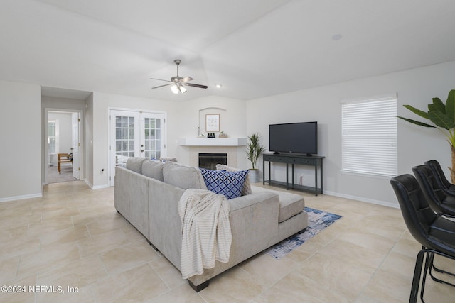 living room with a wealth of natural light, ceiling fan, and french doors