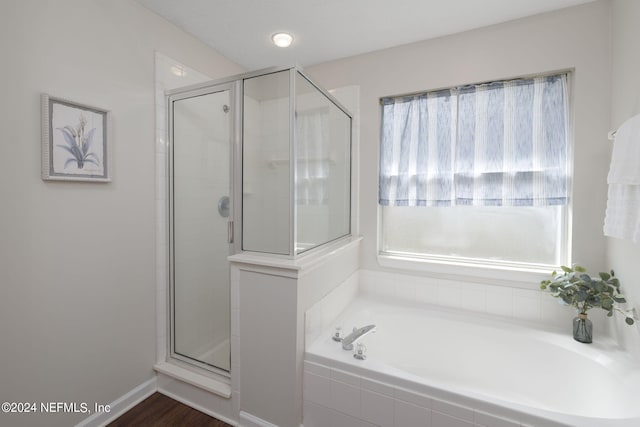 bathroom with hardwood / wood-style flooring and separate shower and tub