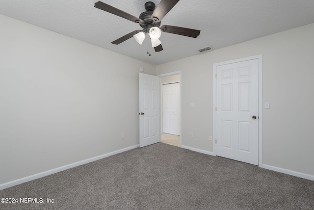 unfurnished bedroom featuring ceiling fan, carpet floors, and a textured ceiling