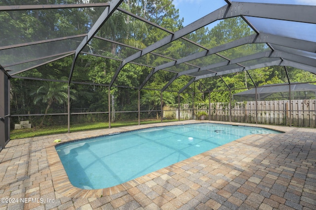 view of swimming pool with a lanai and a patio area