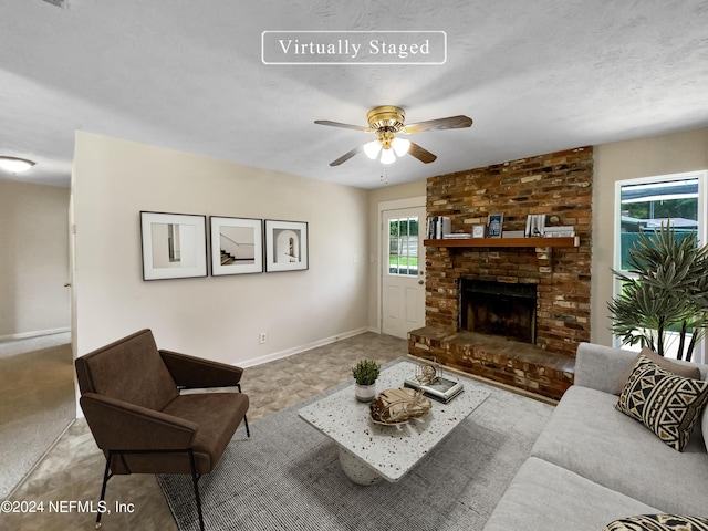 living room featuring a brick fireplace and ceiling fan