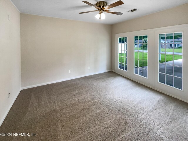 unfurnished room with ceiling fan and carpet