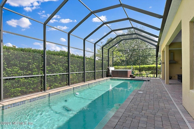 view of swimming pool featuring a lanai and a patio