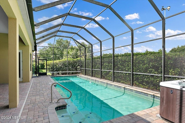 view of pool featuring glass enclosure and a patio