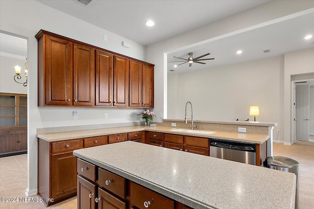 kitchen with kitchen peninsula, ceiling fan with notable chandelier, stainless steel dishwasher, and sink