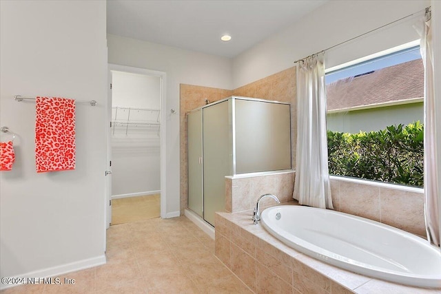 bathroom featuring a wealth of natural light and shower with separate bathtub