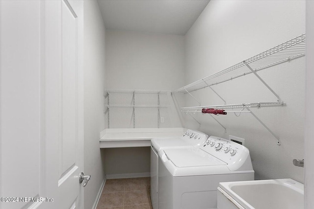 clothes washing area with light tile patterned floors, washer and clothes dryer, and sink