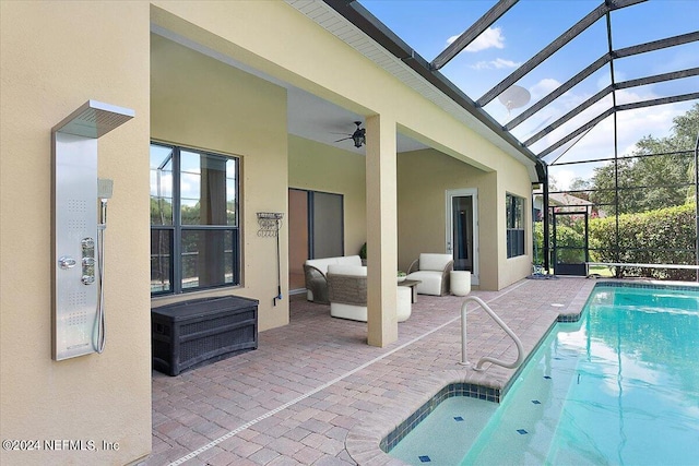 view of swimming pool featuring an outdoor living space, ceiling fan, a patio, and glass enclosure