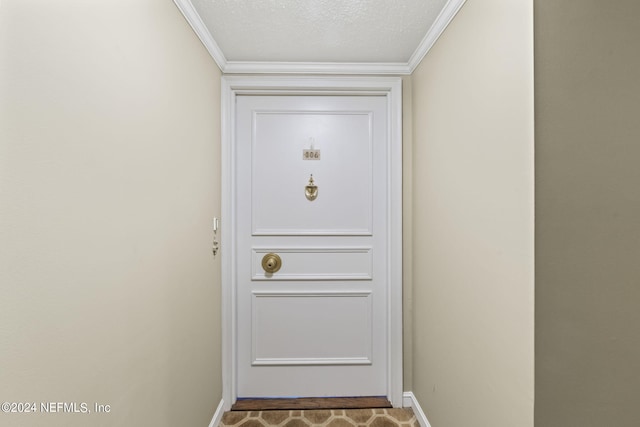 entryway featuring a textured ceiling and ornamental molding