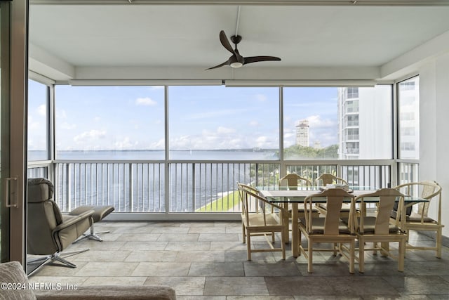 sunroom with a water view and ceiling fan