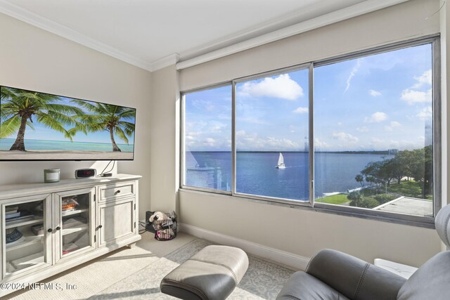 sitting room with a water view and crown molding