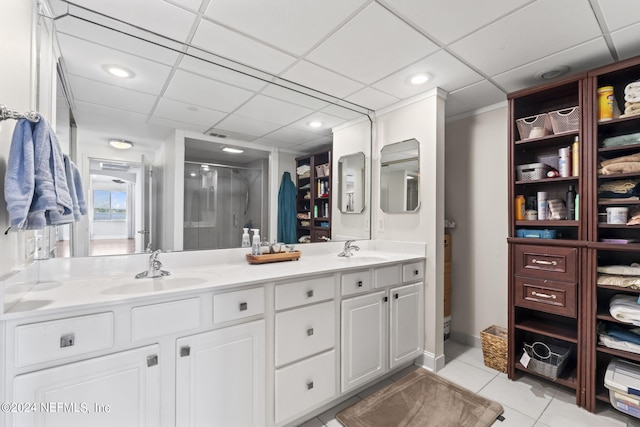 bathroom with tile patterned floors, a paneled ceiling, vanity, and a shower with shower door