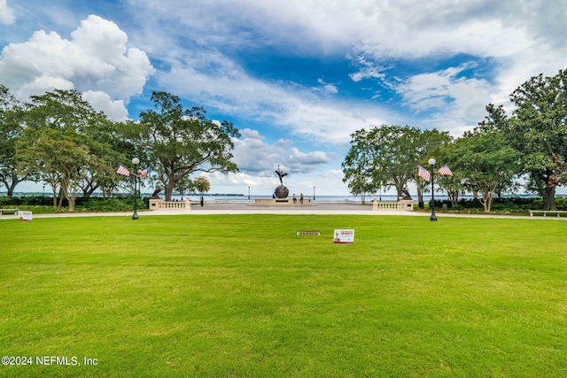 view of property's community featuring a lawn and a water view