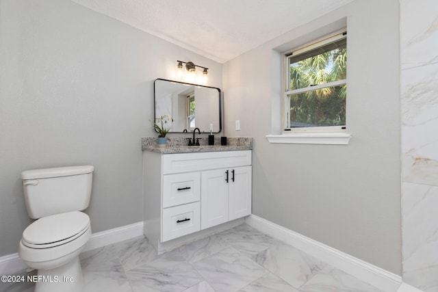 bathroom featuring vanity, a textured ceiling, and toilet