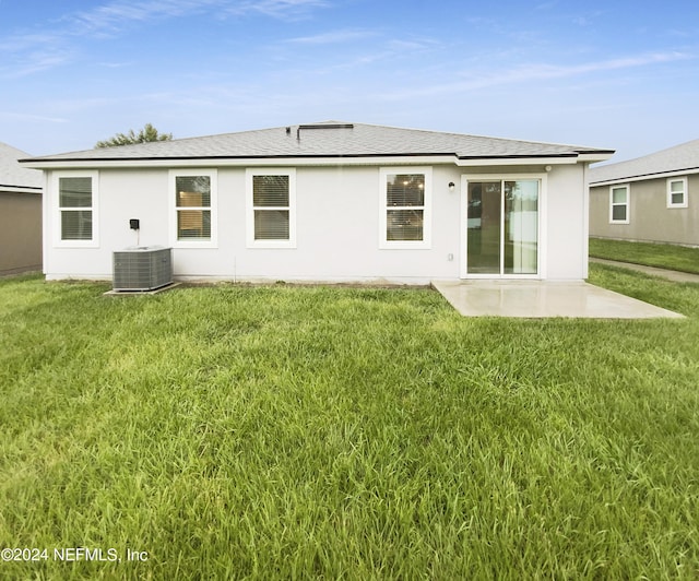 back of house with a lawn, central AC unit, and a patio area