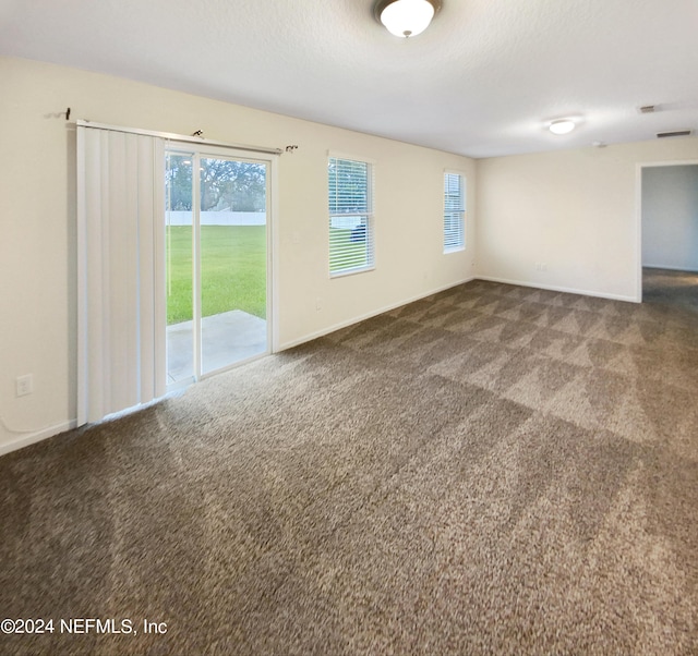 carpeted spare room featuring a textured ceiling