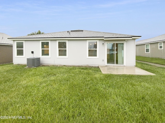 rear view of property featuring cooling unit, a lawn, and a patio