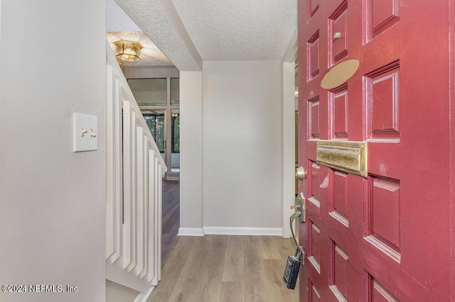 entrance foyer with a textured ceiling and light wood-type flooring