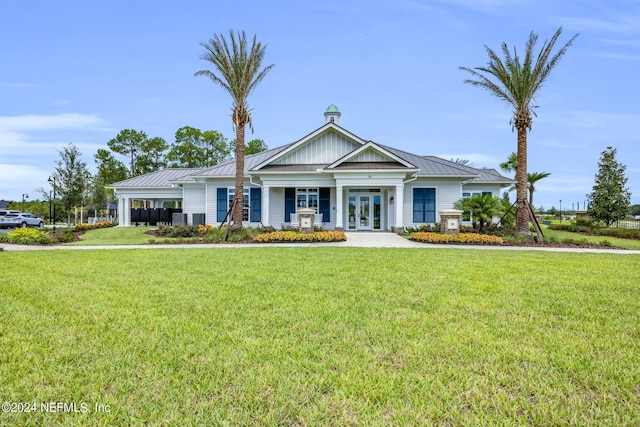 view of front of house with central AC, french doors, and a front yard