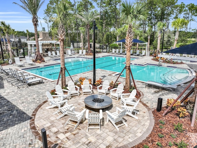 view of pool with a pergola, a fire pit, and a patio area