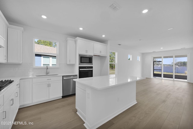 kitchen featuring tasteful backsplash, built in microwave, sink, dishwasher, and black oven