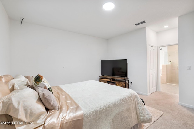 bedroom with light carpet, a closet, and connected bathroom