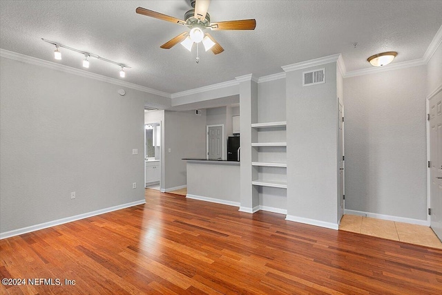 unfurnished living room featuring a textured ceiling, wood finished floors, a ceiling fan, visible vents, and crown molding