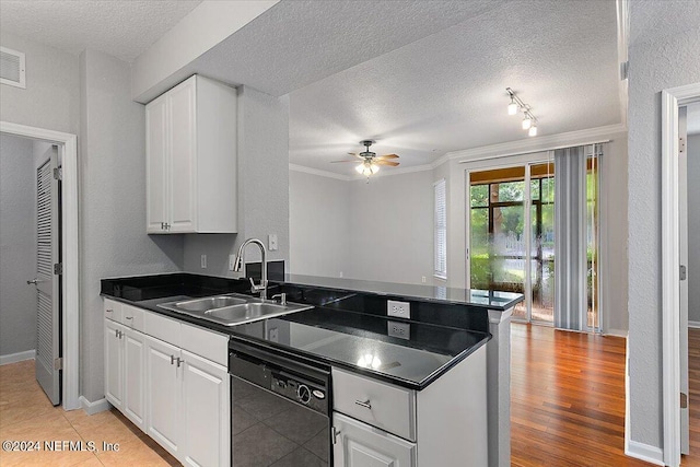 kitchen featuring white cabinets, dishwasher, dark countertops, a textured ceiling, and a sink