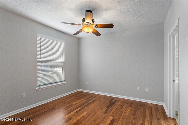 spare room featuring ceiling fan, a textured ceiling, dark wood finished floors, and baseboards