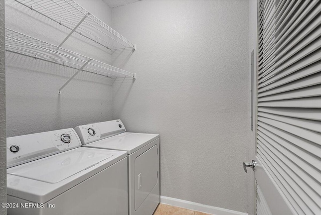 laundry area featuring laundry area, washing machine and dryer, baseboards, and a textured wall