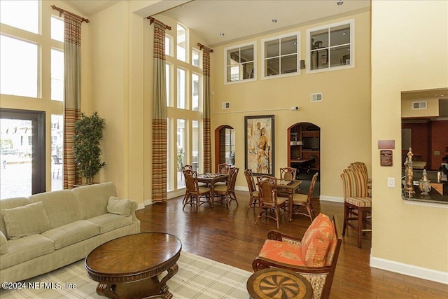 living room featuring wood finished floors, visible vents, and a healthy amount of sunlight