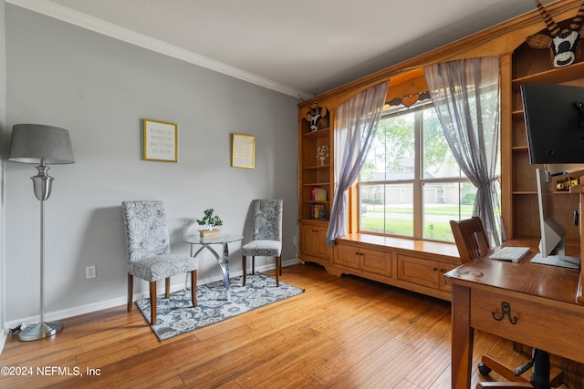 living area with ornamental molding, a wealth of natural light, and light hardwood / wood-style flooring