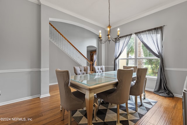 dining room featuring hardwood / wood-style flooring, ornamental molding, and an inviting chandelier