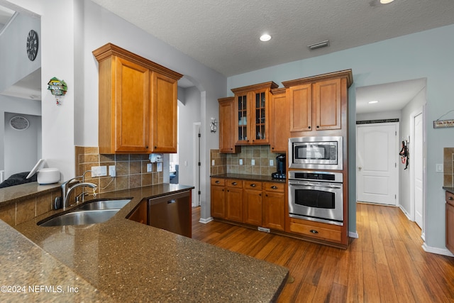 kitchen featuring sink, decorative backsplash, hardwood / wood-style floors, and appliances with stainless steel finishes