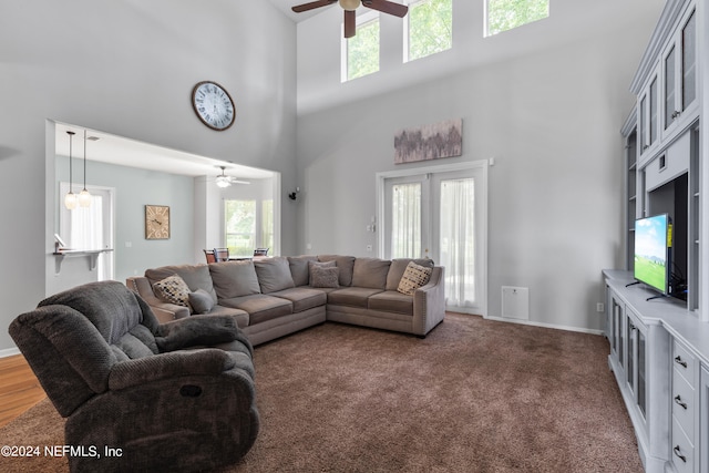 carpeted living room featuring a high ceiling, ceiling fan, and french doors