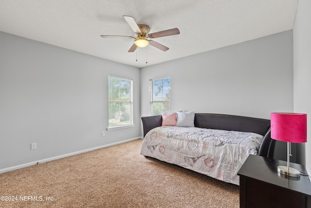 bedroom with ceiling fan, a textured ceiling, and carpet flooring