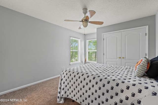 bedroom with ceiling fan, carpet floors, a closet, and a textured ceiling