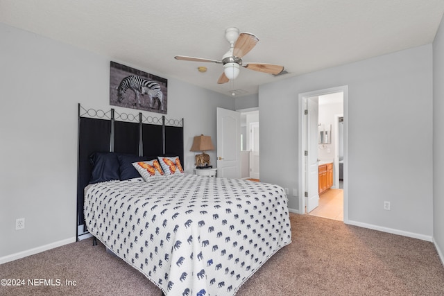 bedroom featuring ceiling fan, light colored carpet, ensuite bathroom, and a textured ceiling