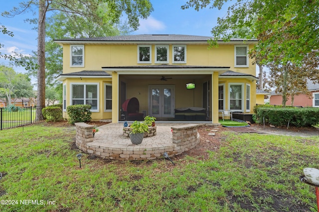 rear view of house featuring a yard, ceiling fan, a sunroom, a patio area, and french doors