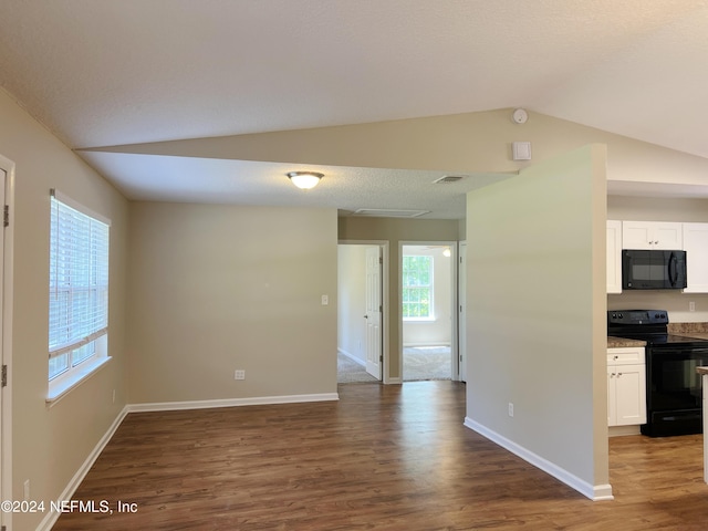 interior space featuring black appliances, white cabinets, dark wood-type flooring, and vaulted ceiling