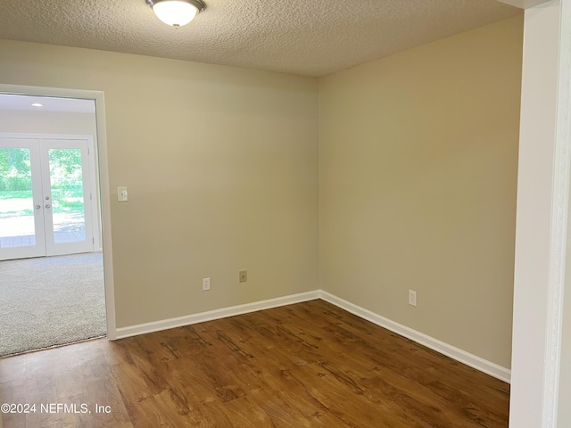 unfurnished room featuring french doors, a textured ceiling, and wood-type flooring