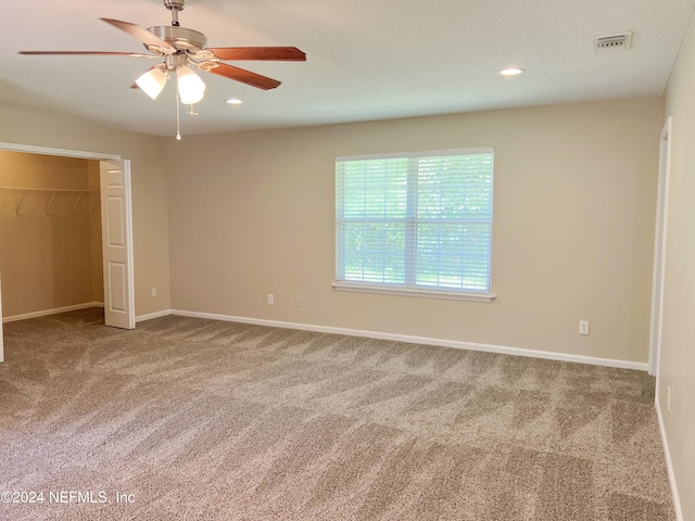 unfurnished bedroom with carpet, ceiling fan, and a closet