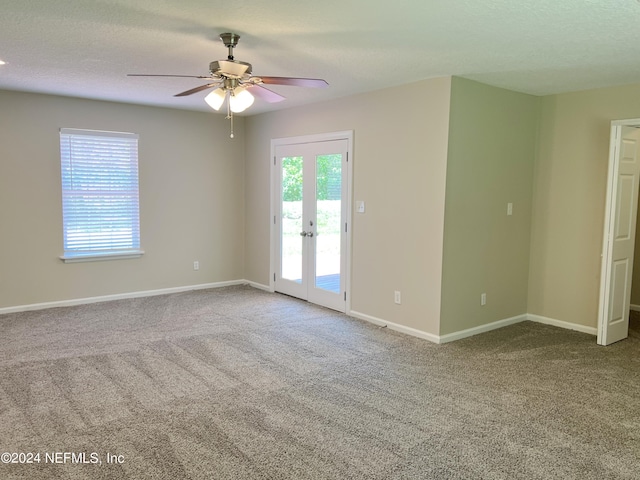 spare room with carpet flooring, ceiling fan, french doors, and a textured ceiling