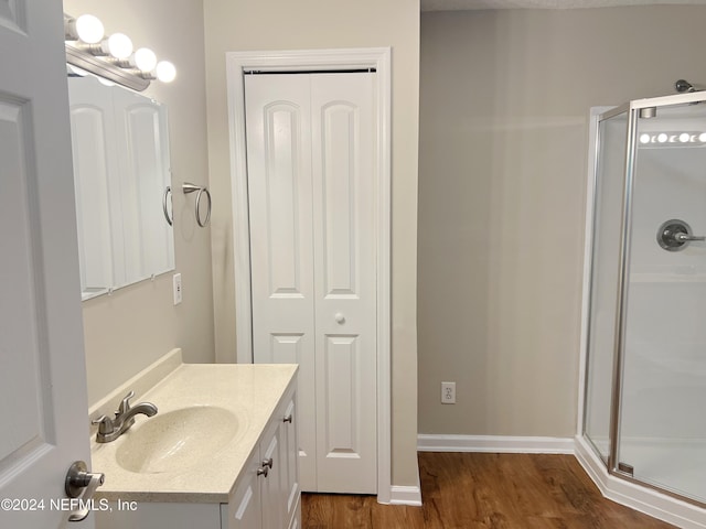 bathroom featuring vanity, wood-type flooring, and walk in shower