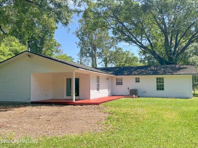 back of property with central AC and a yard