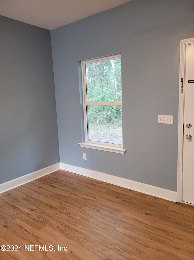 spare room with light wood-style floors and baseboards